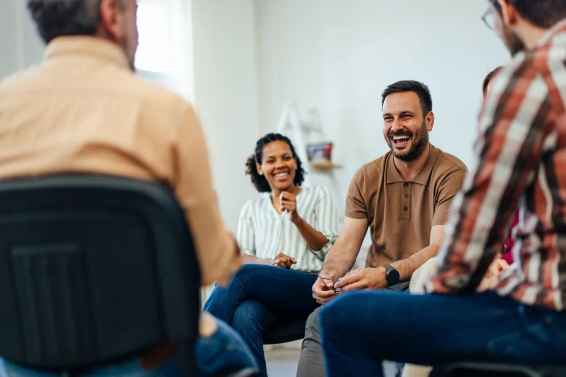 People talking and laughing together during a group session